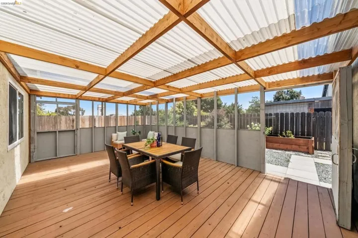 Covered patio featuring wood-finish decking and a translucent corrugated roof
