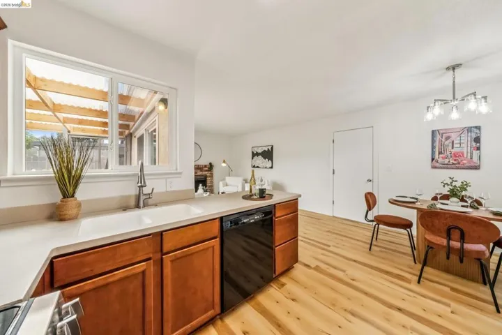 Kitchen featuring light wood-finish cabinetry, light-toned countertops, and a double basin sink