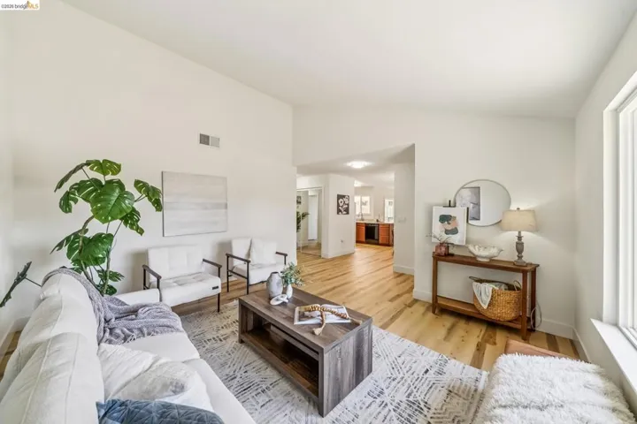 Spacious living area featuring light wood-finish flooring and vaulted ceilings
