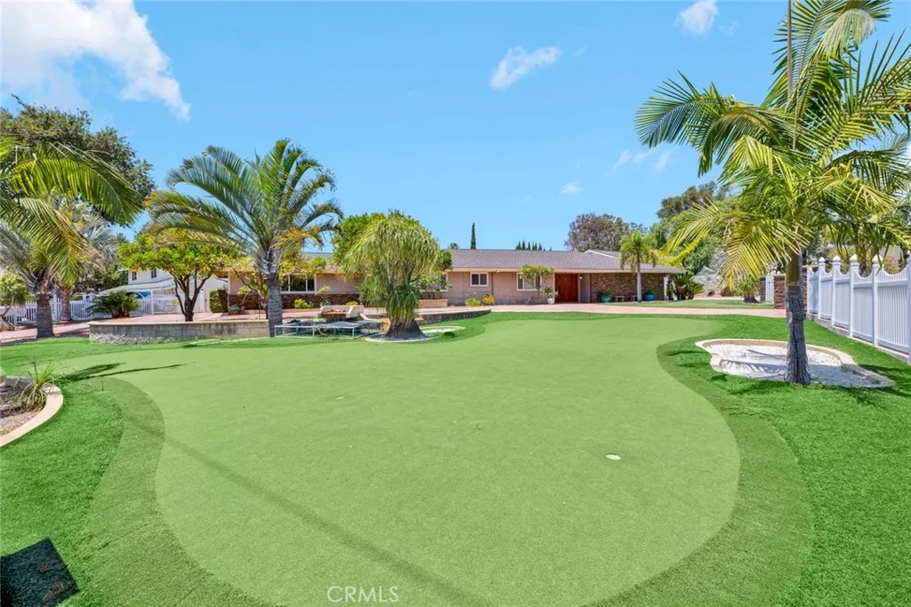 Beautiful and spacious front yard completely gated and fenced with wrought iron fencing, and artificial turf.