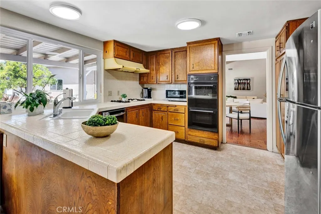U shaped kitchen with window overlooking patio and backyard.