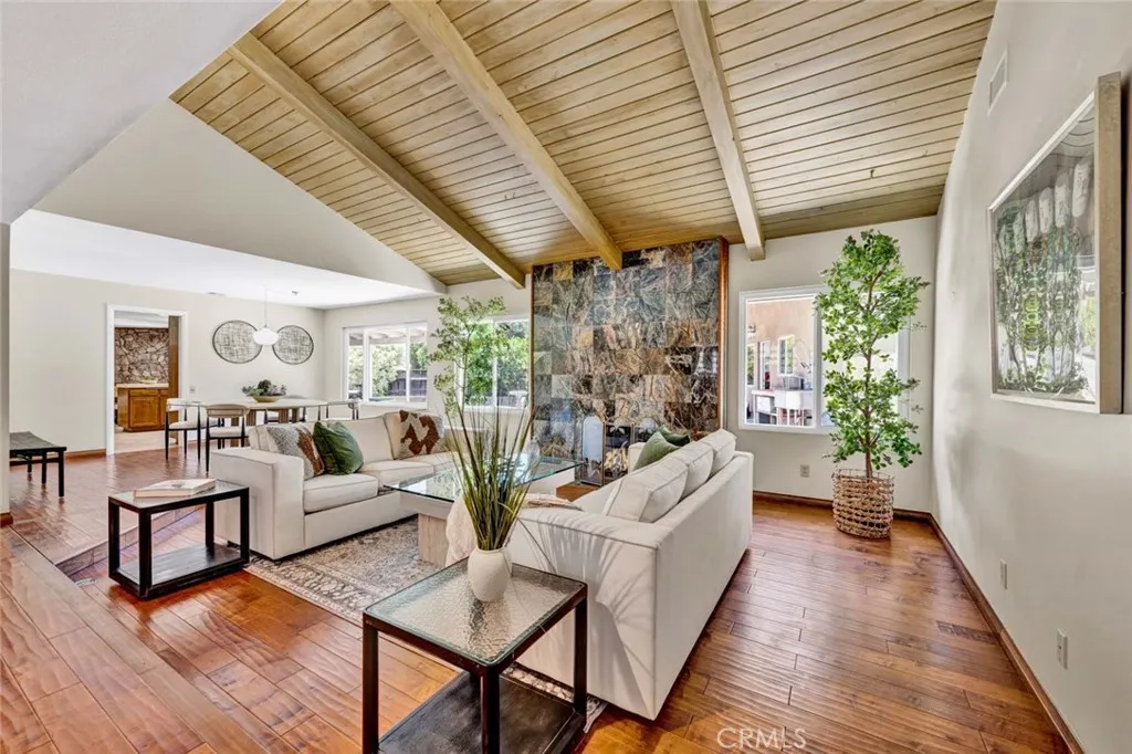 Living room with fireplace and hearth, vaulted ceiling.