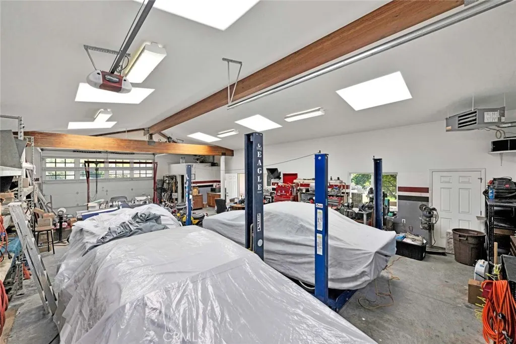 Interior of garage showing pedestrian door and door from driveway and gate.