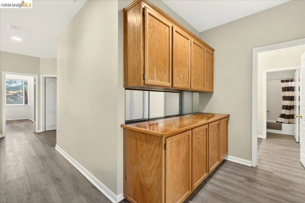 Integrated wood-finish cabinetry with a countertop, complemented by mirrored backsplash panels