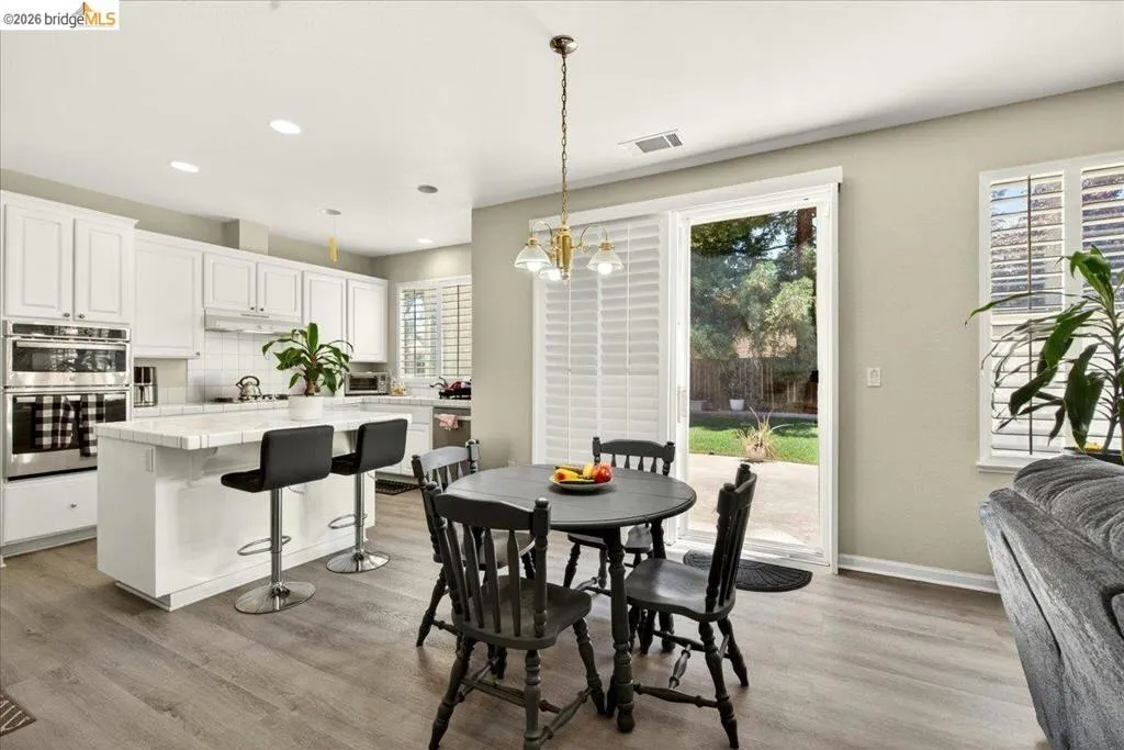 Open-concept kitchen and dining area featuring wood-finish flooring