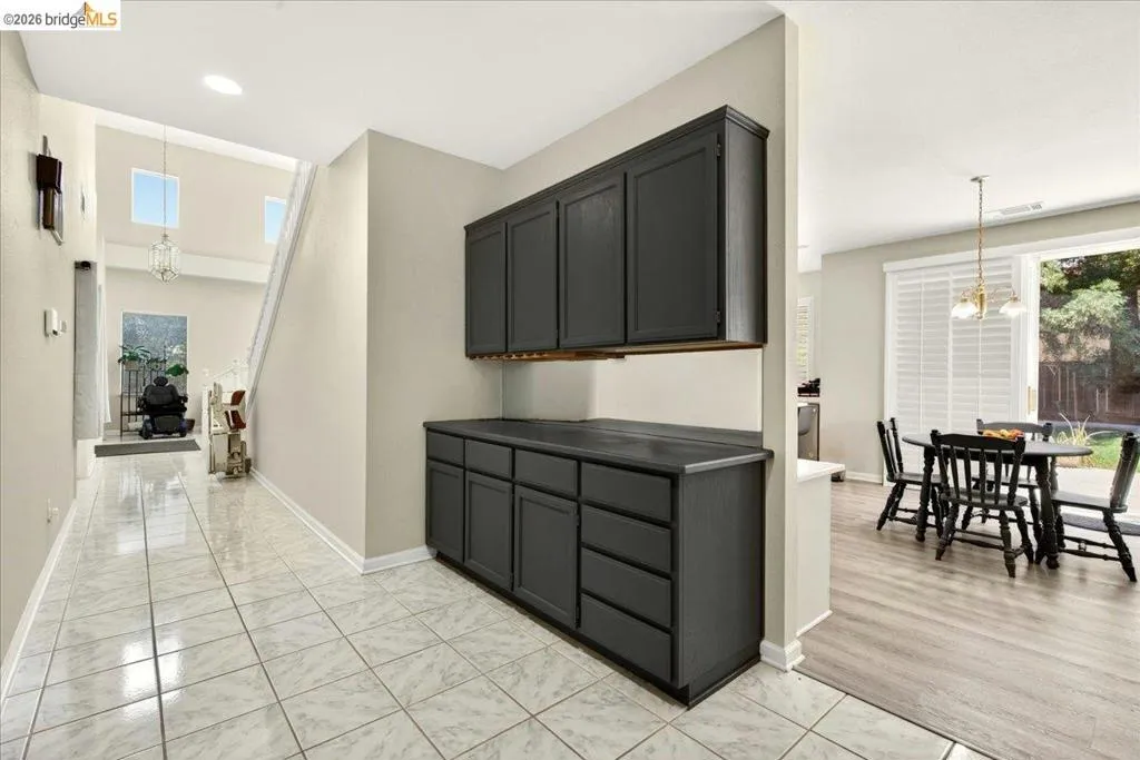Entryway with ceramic tile flooring leading to a dining area with wood-finish flooring