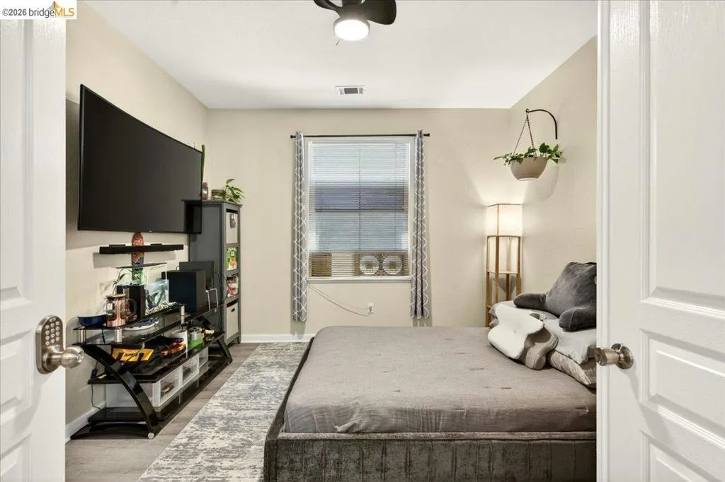 Room featuring a window with blinds, wood-finish flooring, a ceiling fan, and painted walls