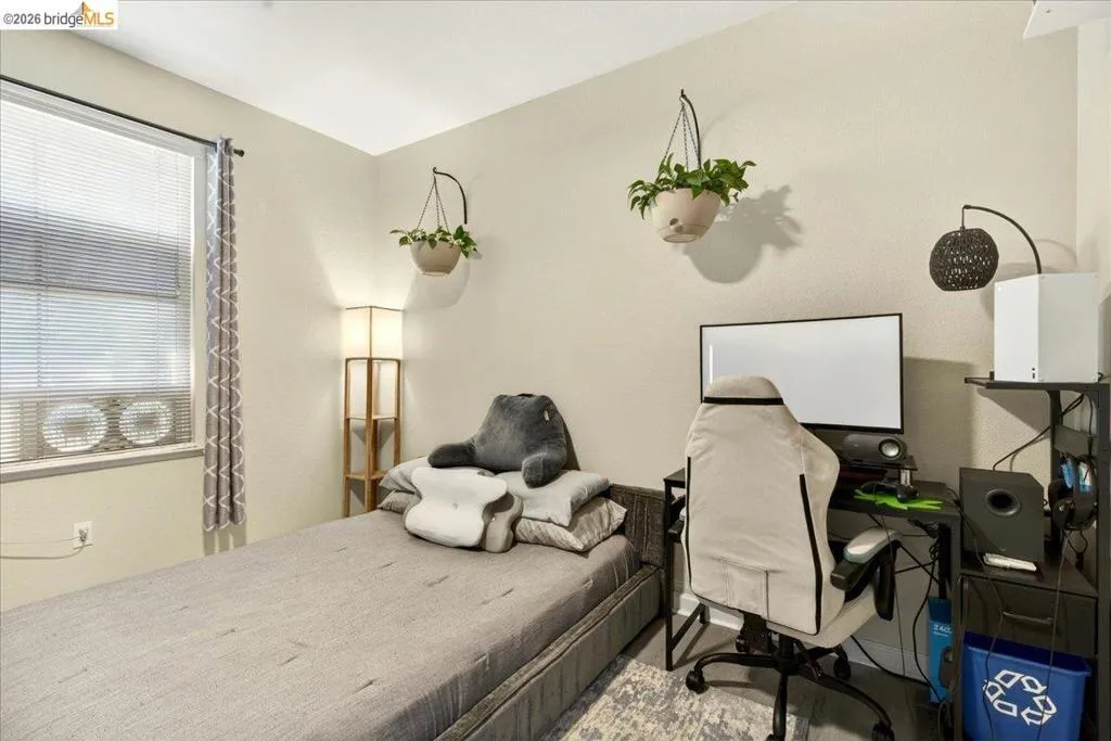 Neutral wall tones complement the window with horizontal blinds and air conditioning unit