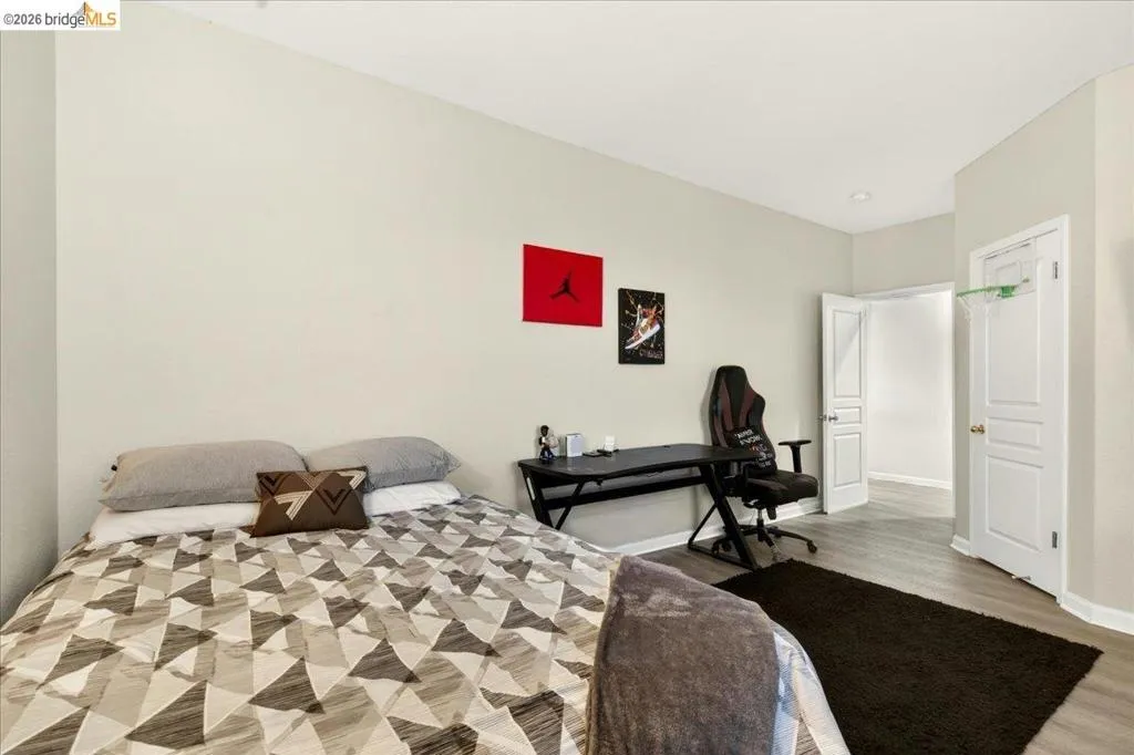 Spacious room featuring neutral painted walls and wood-finish flooring