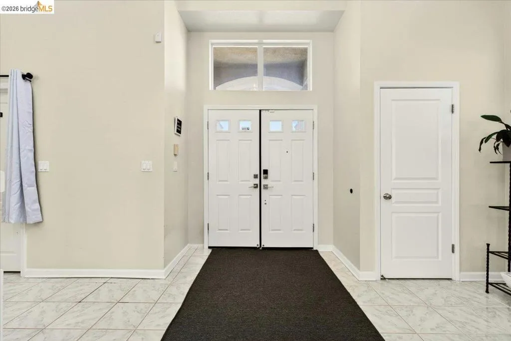 Foyer with a double entry door featuring glass inserts and a transom window