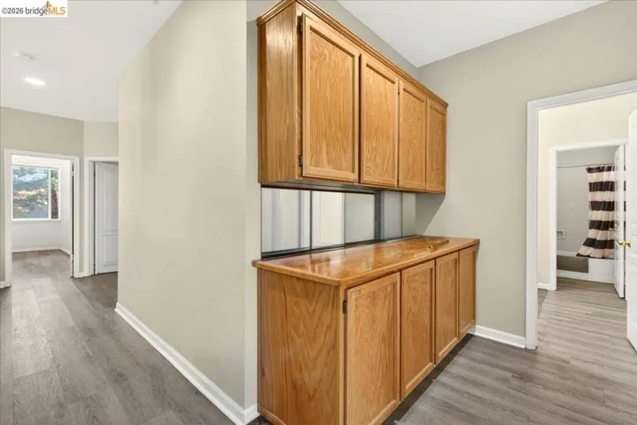 Integrated wood-finish cabinetry with a countertop, complemented by mirrored backsplash panels
