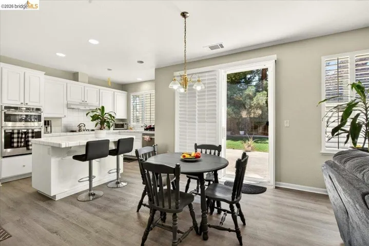 Open-concept kitchen and dining area featuring wood-finish flooring
