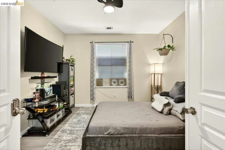 Room featuring a window with blinds, wood-finish flooring, a ceiling fan, and painted walls