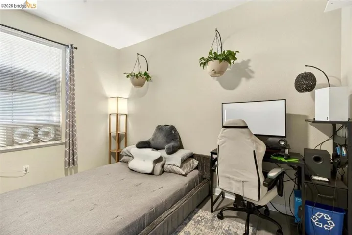 Neutral wall tones complement the window with horizontal blinds and air conditioning unit