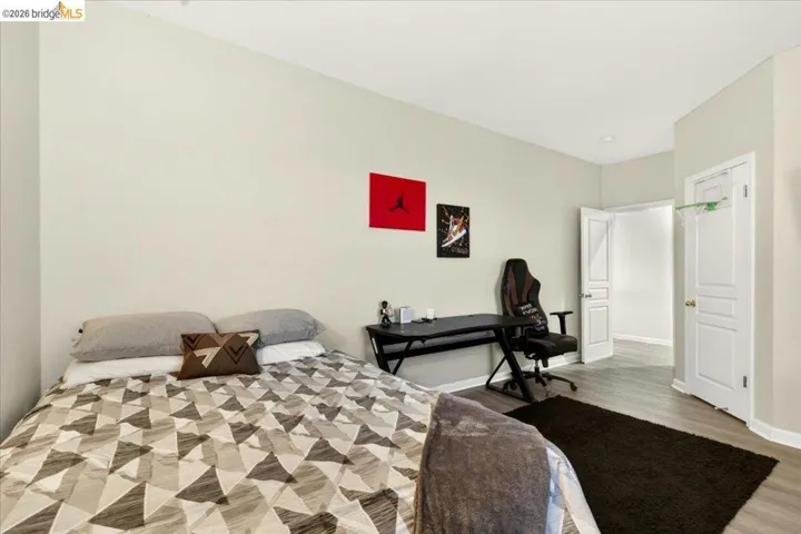 Spacious room featuring neutral painted walls and wood-finish flooring