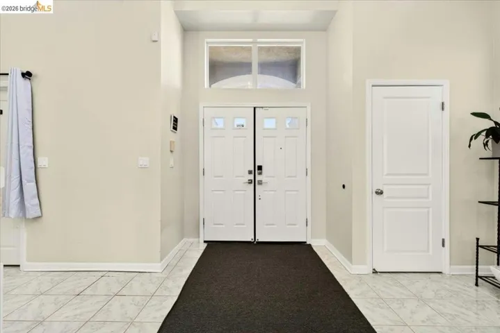 Foyer with a double entry door featuring glass inserts and a transom window