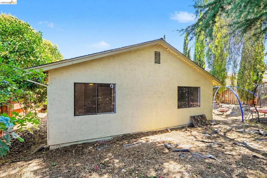 Cream-colored stucco exterior with a gabled roofline and dark-trimmed windows