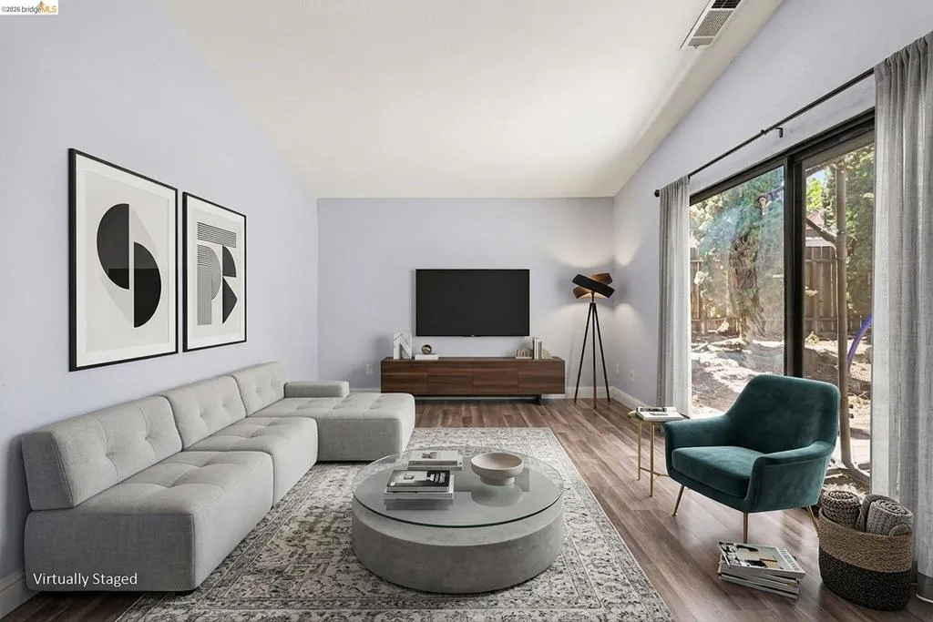 Living area featuring wood-finish flooring, a vaulted ceiling, and sliding glass doors to outdoor space