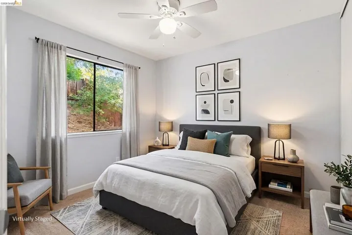 Carpeted bedroom with a window featuring exterior foliage and natural light