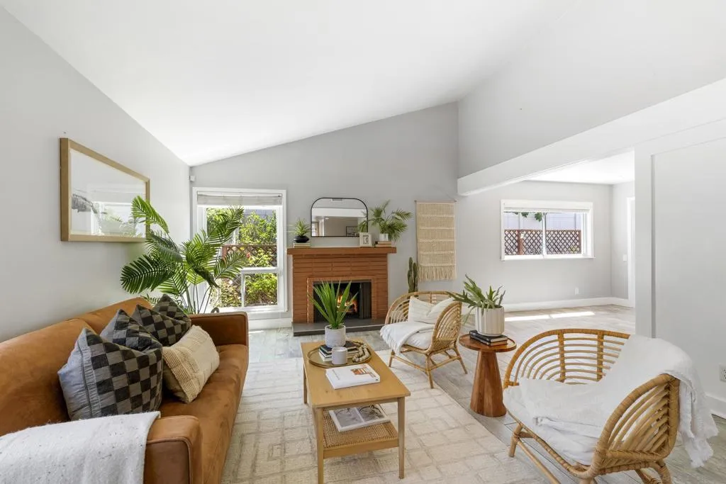 Spacious living room highlighted by vaulted ceilings and a charming fireplace