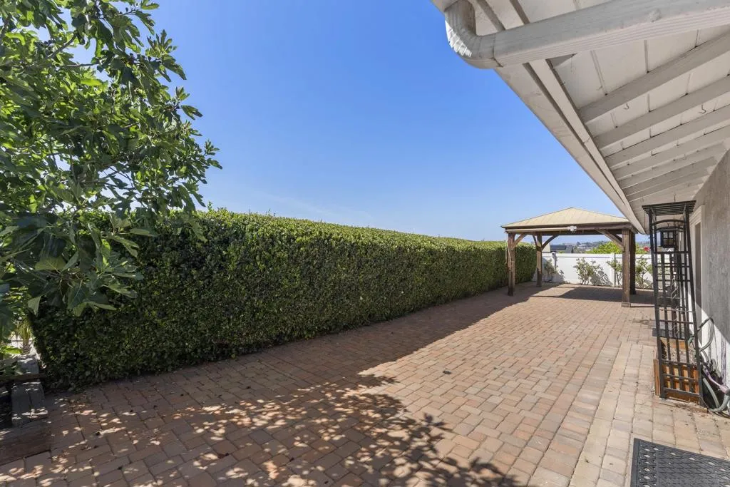 Beautiful brick and hedged-lined backyard with a view