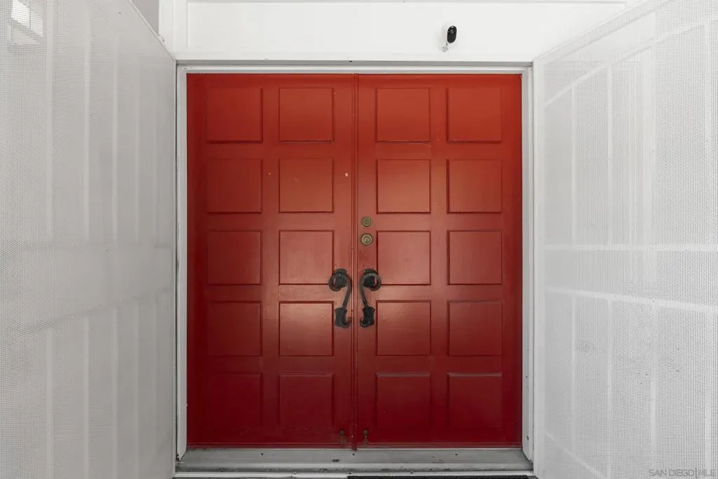 Red entry door creates a memorable first impression, symbolizing hospitality and good fortune.