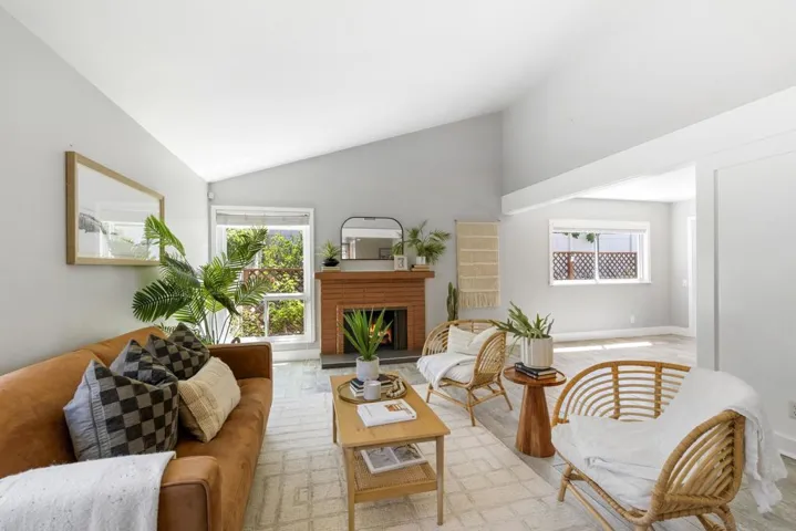 Spacious living room highlighted by vaulted ceilings and a charming fireplace