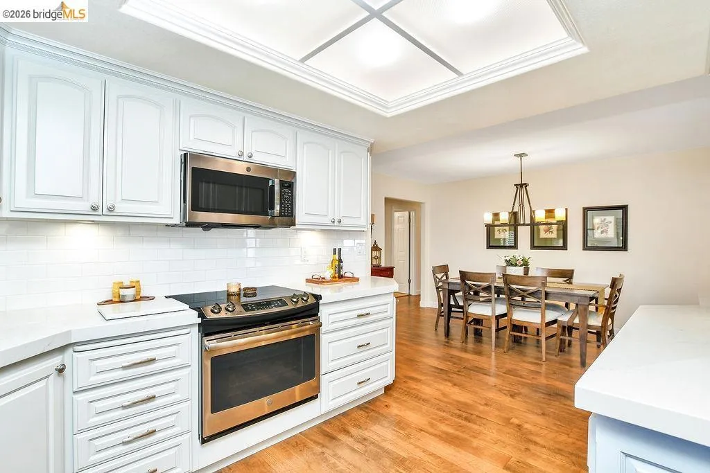 Kitchen featuring white cabinetry, stainless steel appliances, and white subway tile backsplash