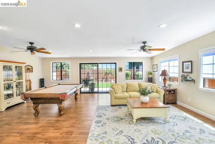 Spacious living area featuring wood-finish flooring and recessed lighting