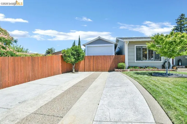 Concrete driveway with decorative striping, bordered by a manicured lawn