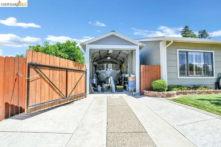 Expansive concrete driveway leading to a sheltered carport structure