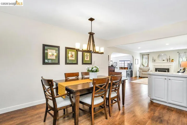Dining area featuring wood-finish flooring, a rectangular wood dining table, and a multi-light chandelier