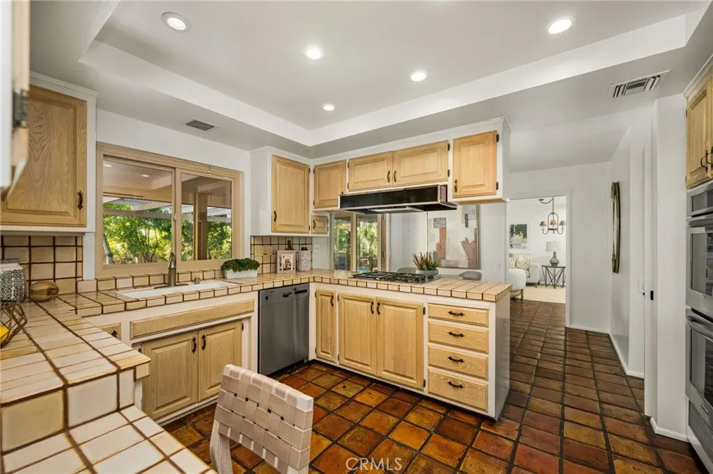 Newer double ovens, gas stove top, dishwasher & refrigerator in the kitchen