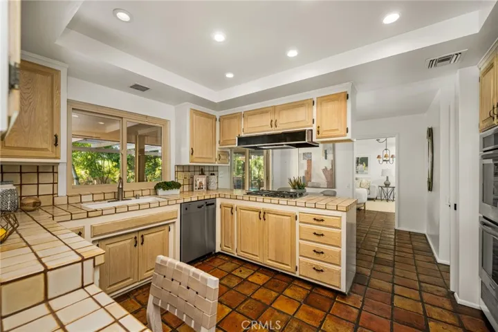 Newer double ovens, gas stove top, dishwasher & refrigerator in the kitchen