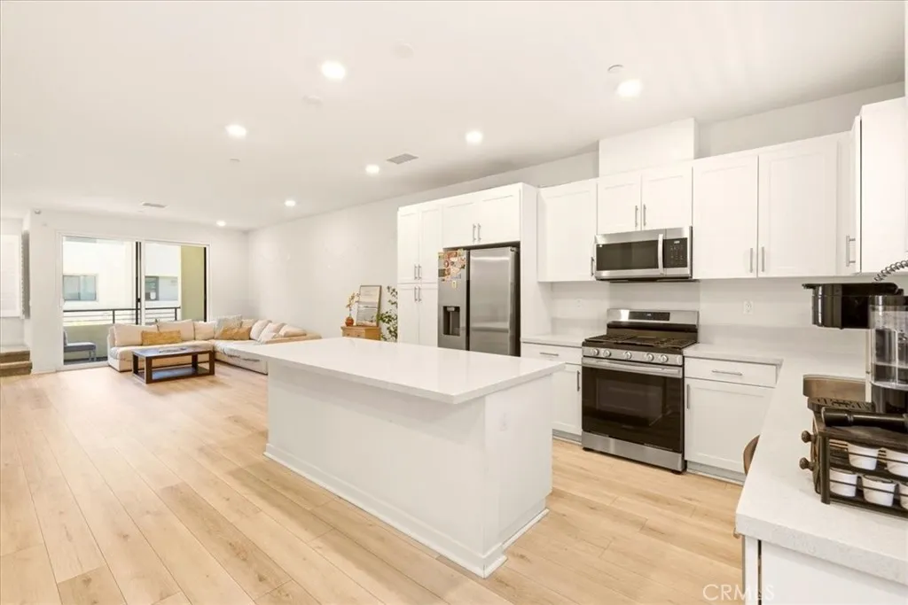 Open concept kitchen flows seamlessly to living room. Big Kitchen island with quartz counter top