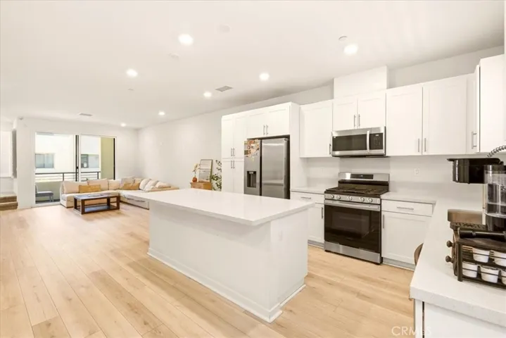 Open concept kitchen flows seamlessly to living room. Big Kitchen island with quartz counter top