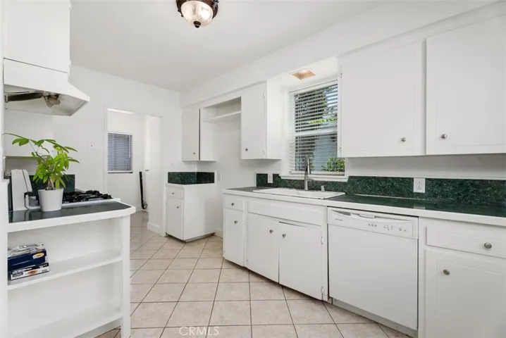 Galley kitchen opens into laundry room on one side and dining room on other.