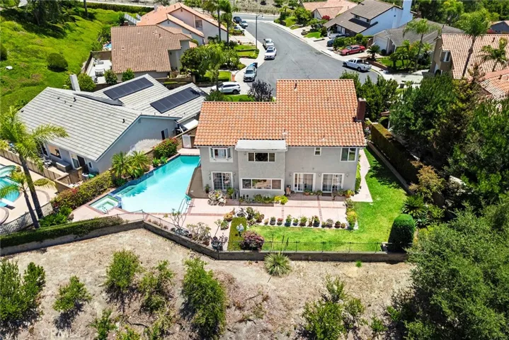 Aerial view highlighting the home's desirable location, spacious lot, private backyard with pool and spa, and surrounding neighborhood setting.