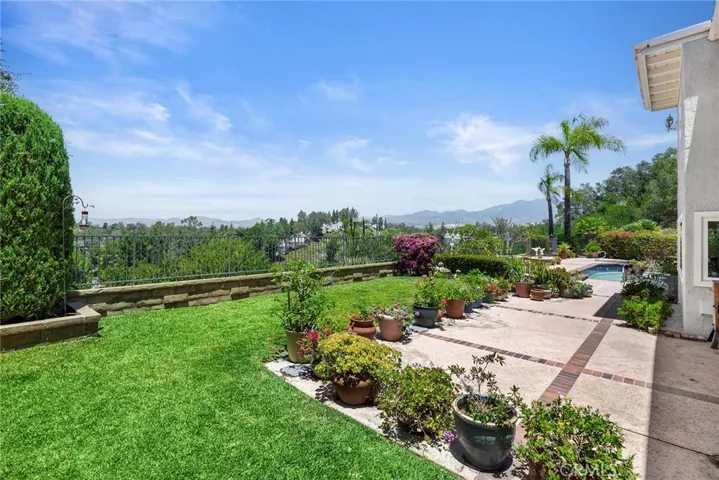 The spacious backyard combines lush lawn, mature landscaping, and scenic views, creating a private outdoor retreat for everyday enjoyment and entertaining.
