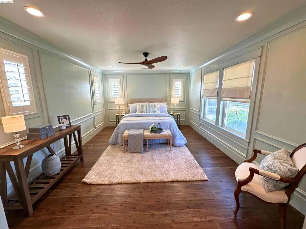 Spacious room featuring wood-finish flooring, recessed lighting, and crown molding