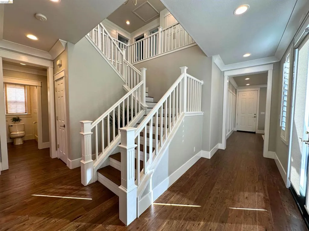 Grand entryway featuring a double staircase with white balusters and dark wood-finish treads