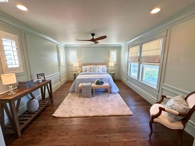 Spacious room featuring wood-finish flooring, recessed lighting, and crown molding