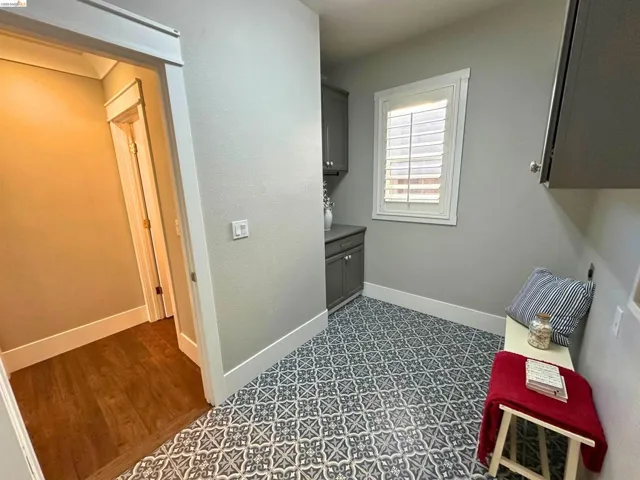 Patterned floor tile with gray base cabinetry and white plantation shutters