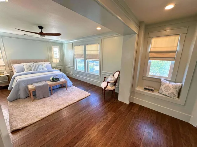 Warm wood-finish flooring complements the detailed wall paneling and crown molding