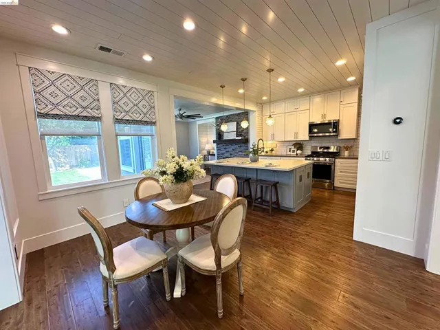 Open-concept kitchen and dining area featuring wood-finish flooring, recessed lighting, a shiplap ceiling, a kitchen island with pendant lighting, and stainless steel appliances