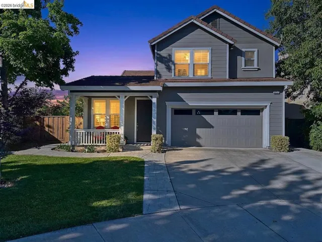 Two-story residence featuring a covered front porch, an attached two-car garage, and a concrete driveway