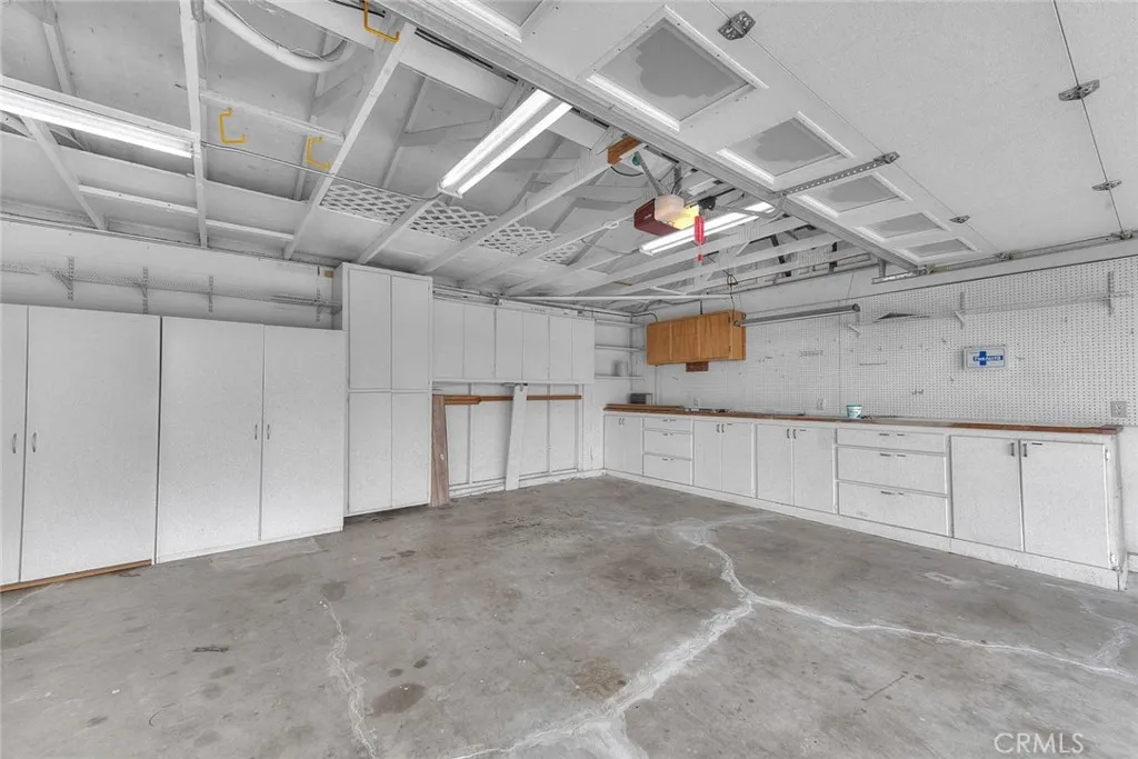 Spacious Garage For Three Vehicles.  Tons Of Cabinets, Shelving And Work Countertop  Rolluo Garage Doors Are Insulated!