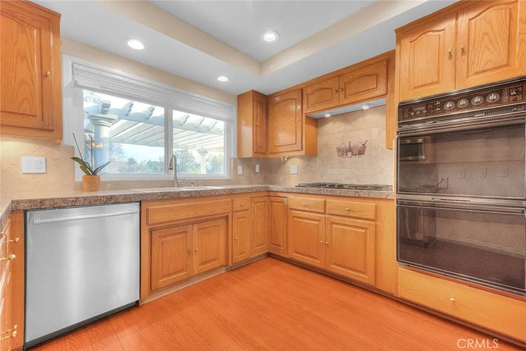 Updated Kitchen With Granite Tile Counters, Dishwasher, Microwave Oven, Five Burner Gas Range, Self Cleaning Double Electric Oven.  Window Above Double Sink Is Pass Thru To Patio