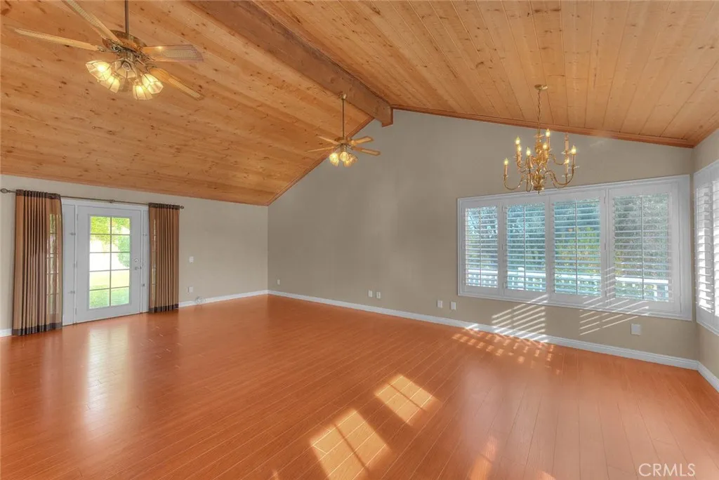 Bonus Room Entering From Living Room.  Left Entry Door Leads To Rear Yard.  Wood Vaulted Ceiling.  Panoramic View Of Lower Rear Area From Windows.