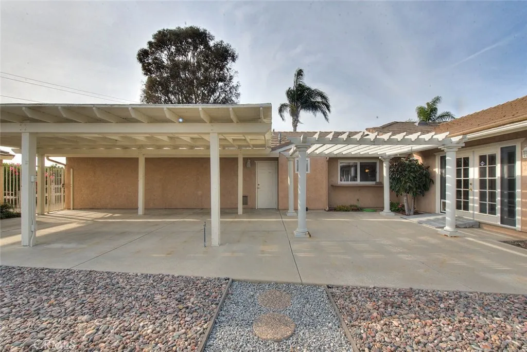 Side View Of Patio Cover.  Door In Middle Leads To Garage.  Window Is Pass Thru From Kitchen To Facilitate Outdoor Meals.  Double Doors To Right To Bonus Room.